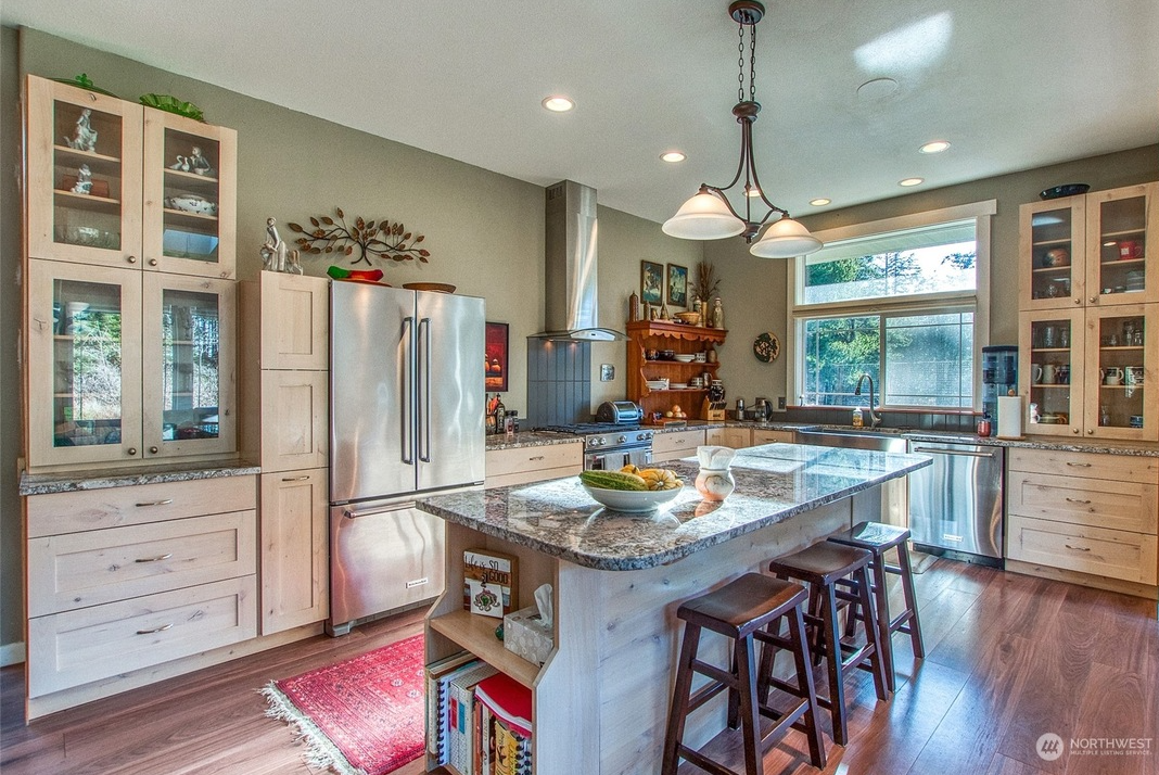 The finished kitchen showing its coordinated cabinetry, appliances, island and lighting